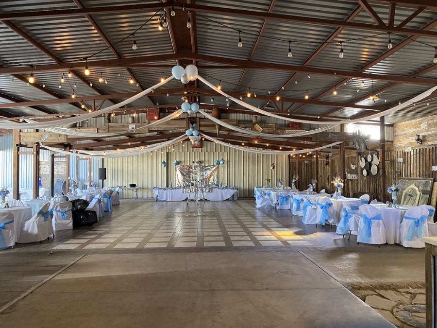Hall decorated with white linens, blue accents, and fabric swags across the ceiling