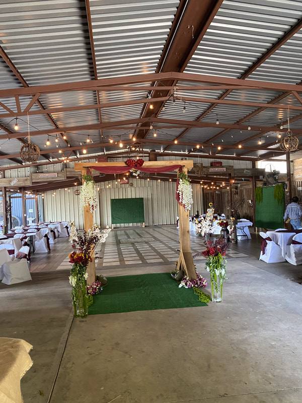 Floral arch and decorated tables inside the barn hall