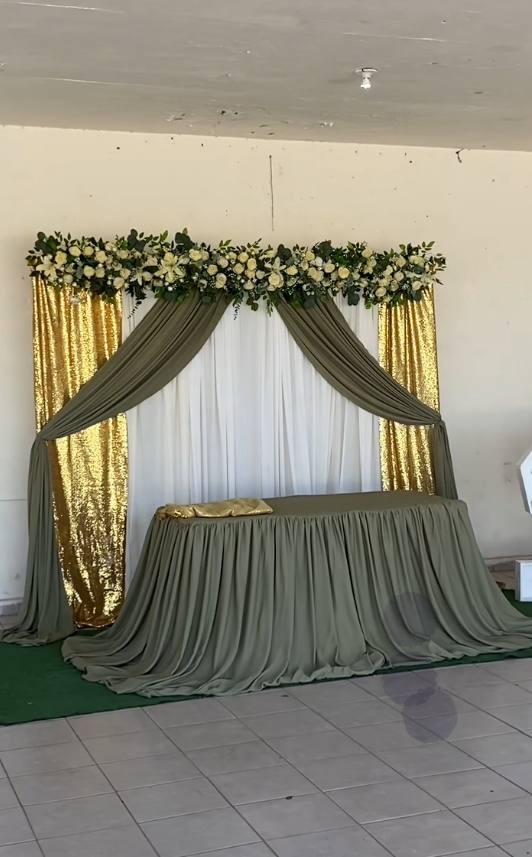Gold sequin and sage drape backdrop behind a decorated table