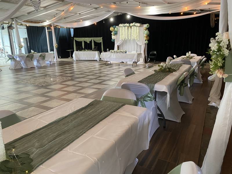 Hall set for a reception with long tables and a decorated head table